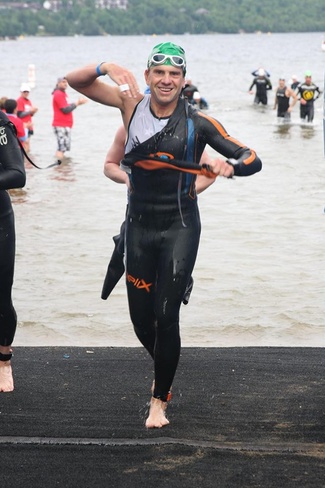 Vlad getting out of wetsuit during race with a smile on his face