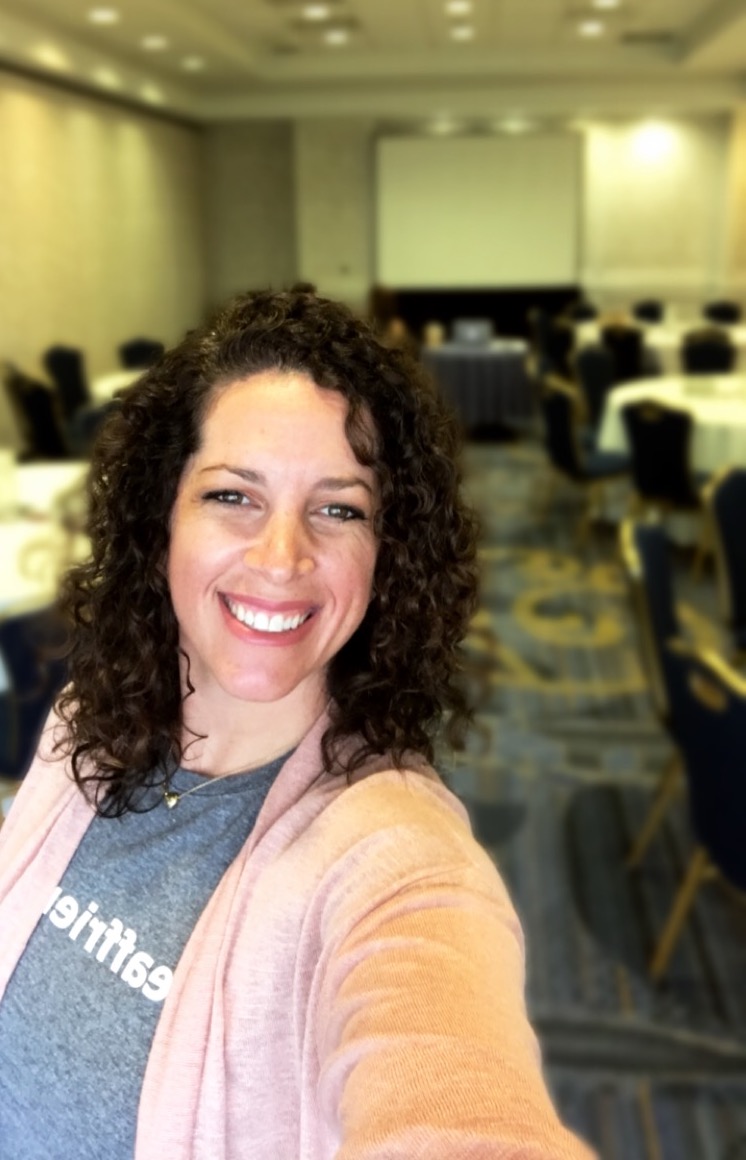 Rachel Berman smiles for the camera in an empty conference room