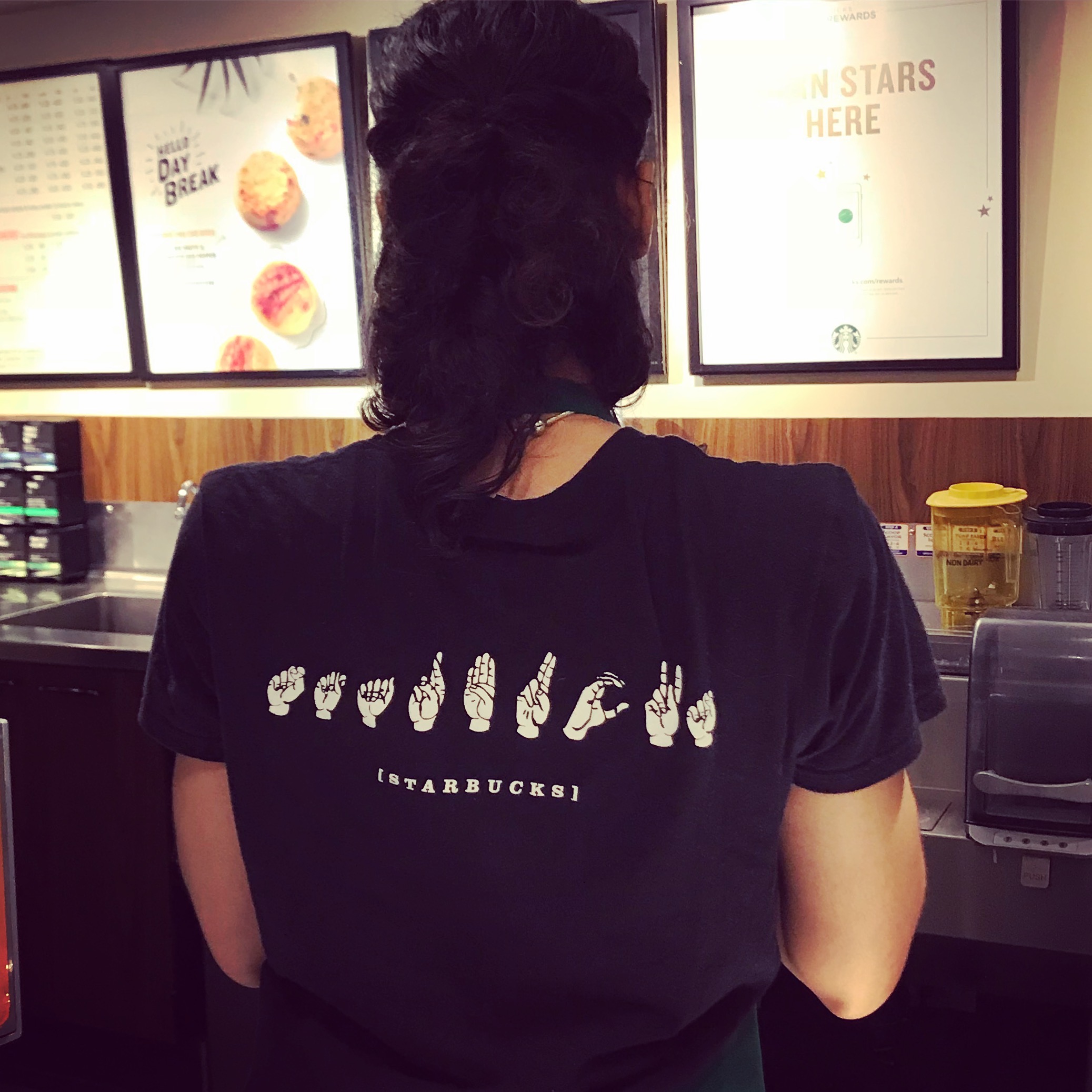 Starbucks shirt fingerspelled in ASL