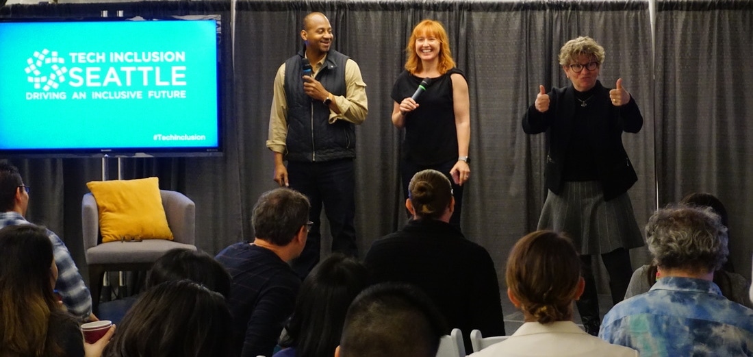 Change Catalyst co-founders Wayne Sutton and Melinda Briana Epler on stage with a sign language interpreter